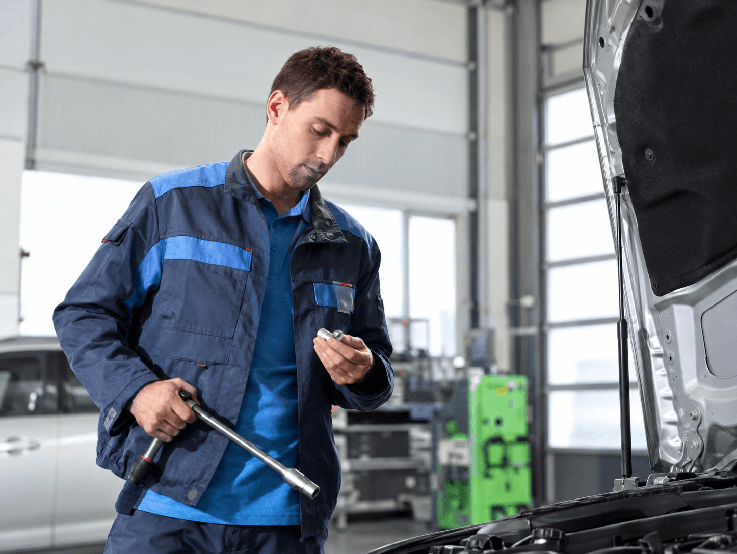 Mecânico Bosch Car Service fazendo diagnóstico com o capô aberto