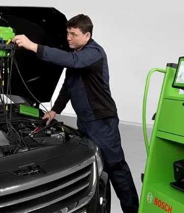 Mecânico fazendo diagnóstico eletrônico do motor com o capô aberto