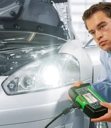 Mecânico testando o farol do veículo com equipamento de diagnóstico